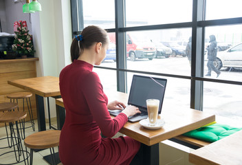 Woman with laptop and a coffee in cafe
