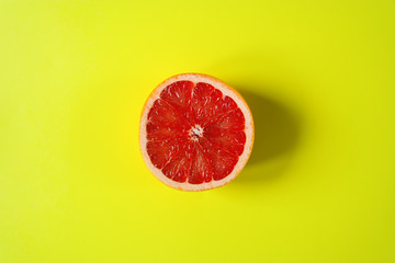  A circle of grapefruit on a bright yellow background. Place for text. Concept background. Flat lay