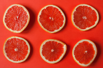 A circles of grapefruit on a bright red background. Concept background. Flat lay. 