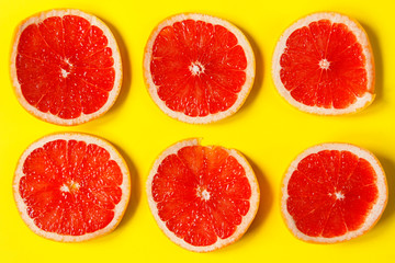 A circles of grapefruit on a bright yellow background. Concept background. Flat lay. 