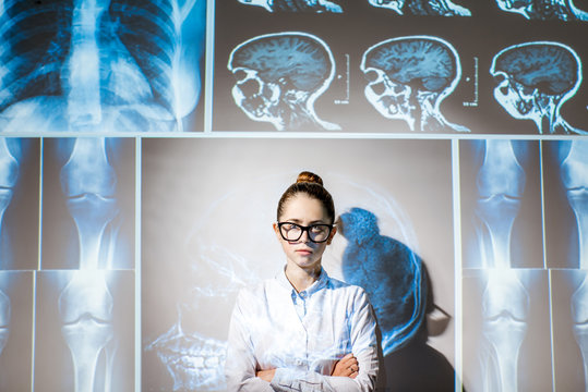 Portrait of a young woman doctor in uniform with projected x-rays of human parts
