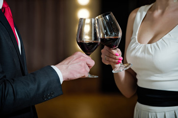 cheers, couple clink glasses with red wine