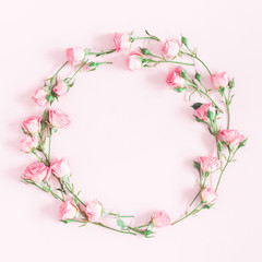 Fototapeta na wymiar Flowers composition. Wreath made of pink rose flowers on pink background. Flat lay, top view, copy space, square