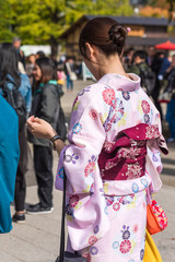 Girl in a pink kimono on city street, Tokyo, Japan. Vertical. Close-up. Back view.