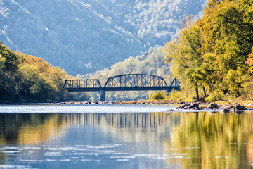 New River Gorge wide canyon water river lake during autumn golden orange foliage in fall by Grandview with peaceful calm tranquil day, closeup of bridge