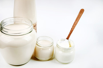 Bottle with milk and a can of sour cream isolated on white background