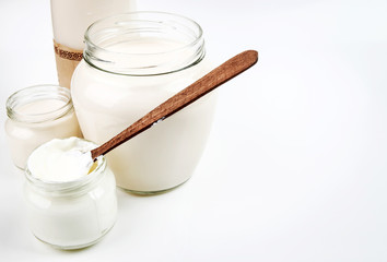 Bottle with milk and a can of sour cream isolated on white background