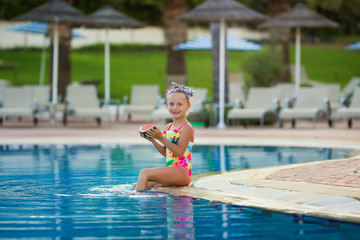 Child eating watermelon outdoor. Kid having fun in swimming pool. Summer vacation and healthy lifestyle concept