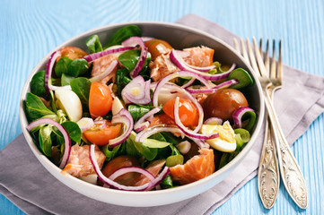 Salad with salmon, tomatoes, eggs and red onion.