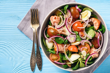 Salad with salmon, tomatoes, eggs and red onion.
