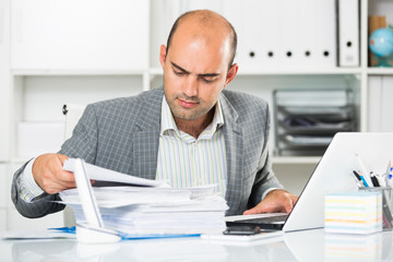 Businessman in shirt viewing documents at the table