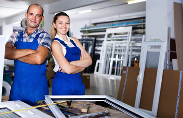 Obraz premium Man and woman in blue overalls standing with hands crossed at workplace