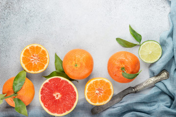 Set of citrus on table: mandarin, grapefruit, lime, tangerine with a knife. Fresh organic juicy fruits.
