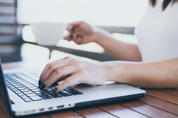 Fototapeta premium Woman working on desk holding a cup of coffee