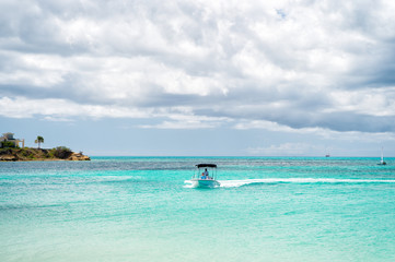 Fototapeta na wymiar Motor boat in caribbean sea on cloudy sky, antigua
