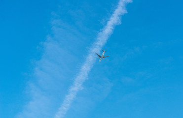 Big white airplane flies in a blue skies
