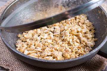 Frying egg with oatmeal in a frying pan. Healthy breakfast, healthy eating, vegan food concept.