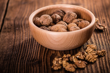 walnuts shells and kernels on old rustic wood background 
