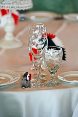 The restaurant on the table is the tableware, beautiful, empty glasses and plates. Close-up. Vertical orientation