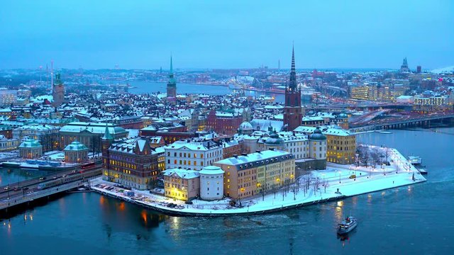 Island Riddarholmen in central Stockholm on a wintry evening with a public ferry passing by.