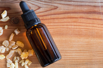 A bottle of frankincense essential oil with frankincense resin, top view