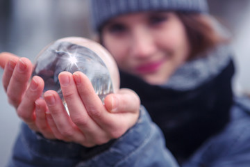 closeup of young woman holding a glass sphere