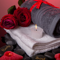 Obraz na płótnie Canvas Spa concept in Valentine's Day, red roses, candles in the shape of heart, spa stones with the inscription soul, body, relax
