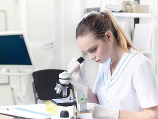 Portrait of a young female lab assistant, doctor or student in a medical suit.