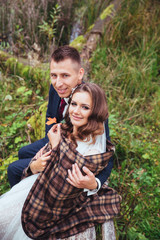 Obraz premium Groom hugging his bride in park. Wedding couple