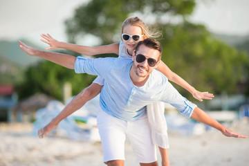 Little girl and happy dad having fun during beach vacation