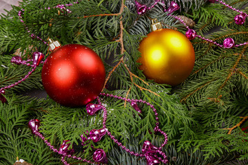 Christmas background, decor, attributes, on a wooden background. Set of fresh fir branches and ornaments of red and gold balls. Cones and bells.