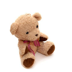 Teddy bear with a red bow on her neck on an isolated background