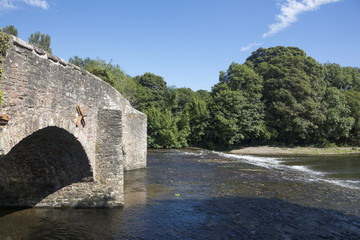 Fototapeta na wymiar The River Exe flows under the medieval stone bridge at Bickley Devon England