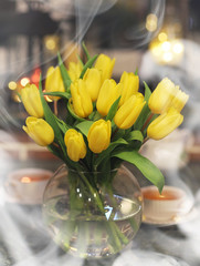 A bouquet of yellow tulips in a vase in the interior of a retro 