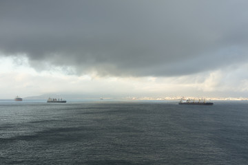 Fototapeta premium Storm clouds over ships in Gibraltar harbour