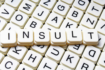 Insult text word crossword title caption label cover background. Alphabet letter toy blocks. White alphabetical letters.
