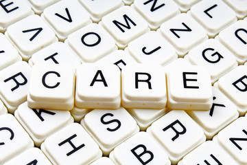 Care text word crossword title caption label cover background. Alphabet letter toy blocks. White alphabetical letters.