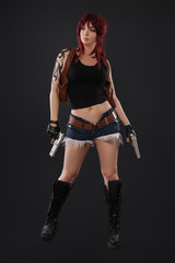 Portrait of sexy woman posing in studio with gun