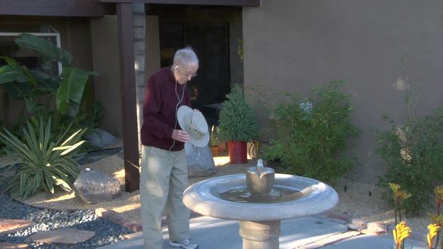 Elderly Man Puts On Hat And Smiles Before Walk