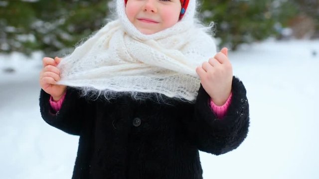 portrait of a child girl in a headscarf in the Urs style on the background of snow and forest. Russia, frost, fairy tale, carnival