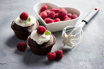 Chocolate muffins or cupcakes with raspberries, healthy breakfast, homemade snack, selective focus, toned image.