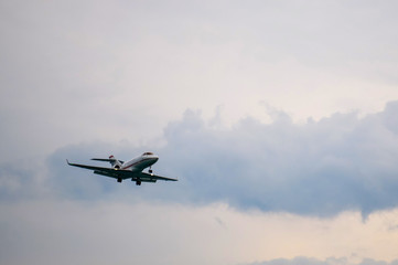 Fototapeta na wymiar Airplane flying in cloudy sky