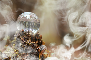 A crystal ball in the smoke. A magical accessory in the woods on