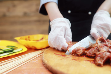 The cook cuts meat for cooking barbecue