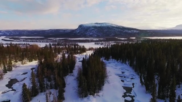 Aerial video of river mountains lakes forest landscape. The village Kvikkjokk, winter time.