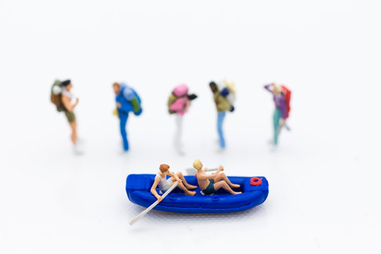 Miniature people : Travelers with paddle boat with group travelers for background. Image use for activities, travel business concept.