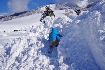 Fototapeta na wymiar 雪山で遊ぶ子供たち