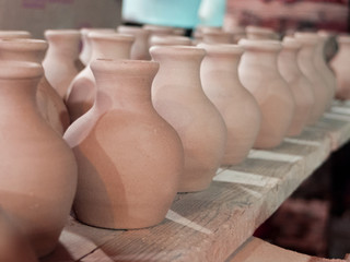 Fototapeta na wymiar clay pots on a shelf in the pottery workshop