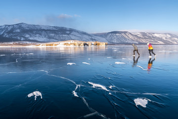 Tourists on skates go to meet the wind on Lake Baikal