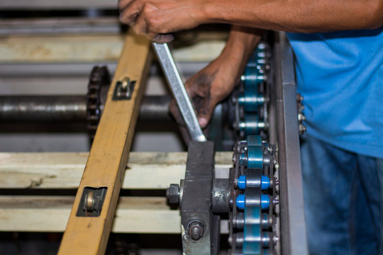 The technician repairing conveyor belt in factory